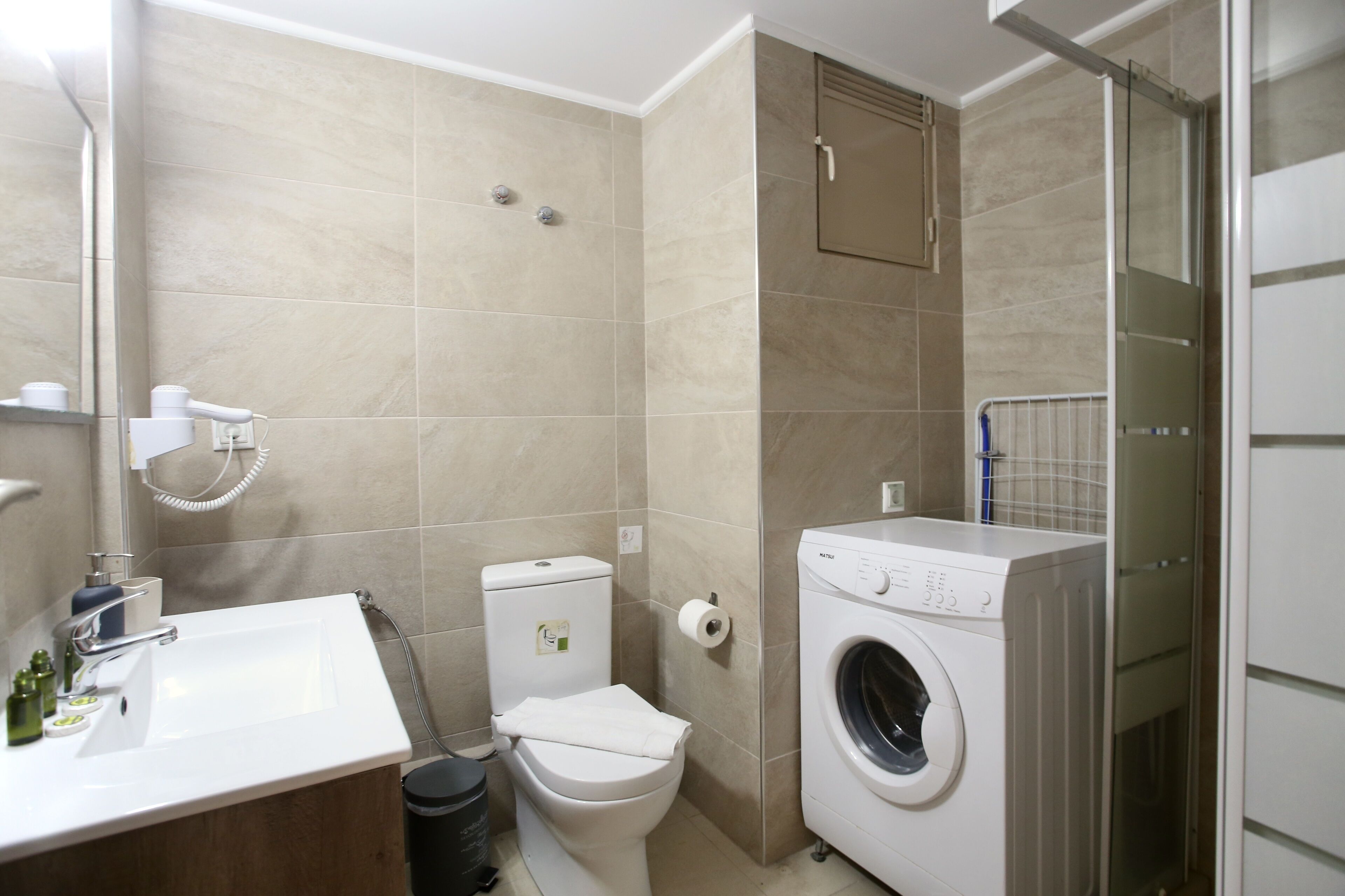 Ein Badezimmer mit Waschbecken, Toilette und Waschmaschine.