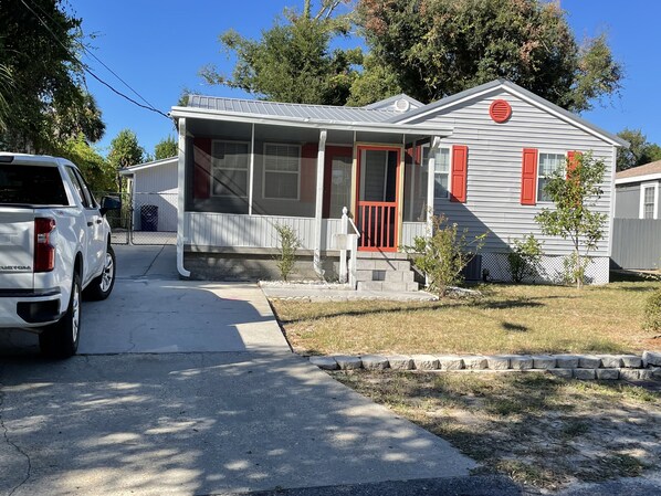 Una casa de un piso con porche delantero, garaje y un pequeño jardín.