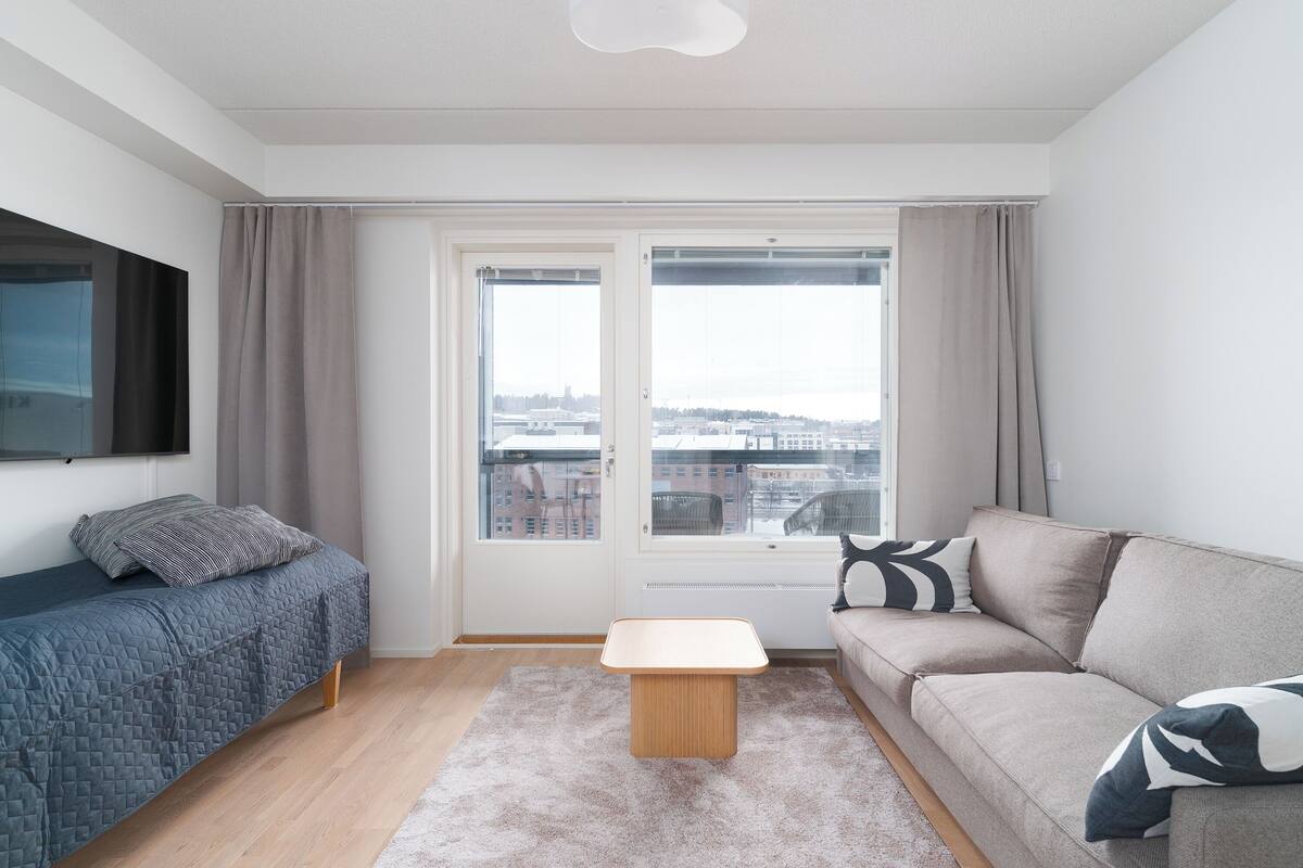A modern living room with a bed, sofa, and a small table.