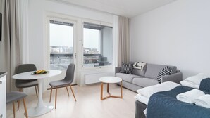 A modern hotel room with a balcony, a sofa, a dining table, and a bed. - Rahulihomes Jyväskylä (Jyväskylä)