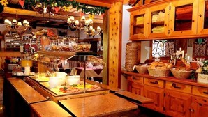 Un restaurant chaleureux avec un buffet, des meubles en bois et des luminaires suspendus.