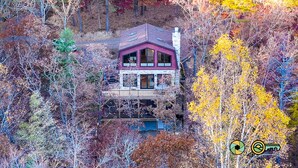 Ein zweistöckiges Haus mit Balkon, umgeben von Herbstlaub.