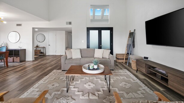 A spacious living room with a large flat-screen TV, a grey sofa, and a wooden coffee table. - Newly Remodeled Home @ the Omni at Rancho Las Palmas in Rancho Mirage! (Rancho Mirage)