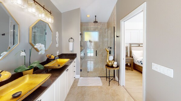 Une salle de bain moderne avec un grand miroir, un lavabo jaune et un espace douche.
