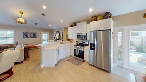 A modern kitchen with white cabinetry, stainless steel appliances, and a central island.