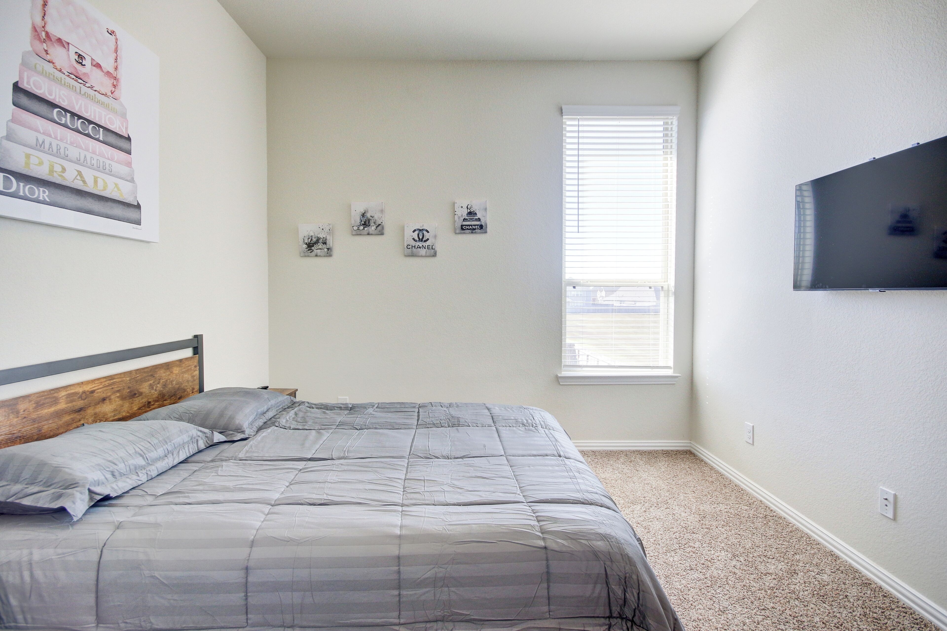 A bedroom with a bed, a window, and wall decorations including brand logos.