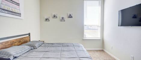A bedroom with a bed, a window, and wall decorations including brand logos.
