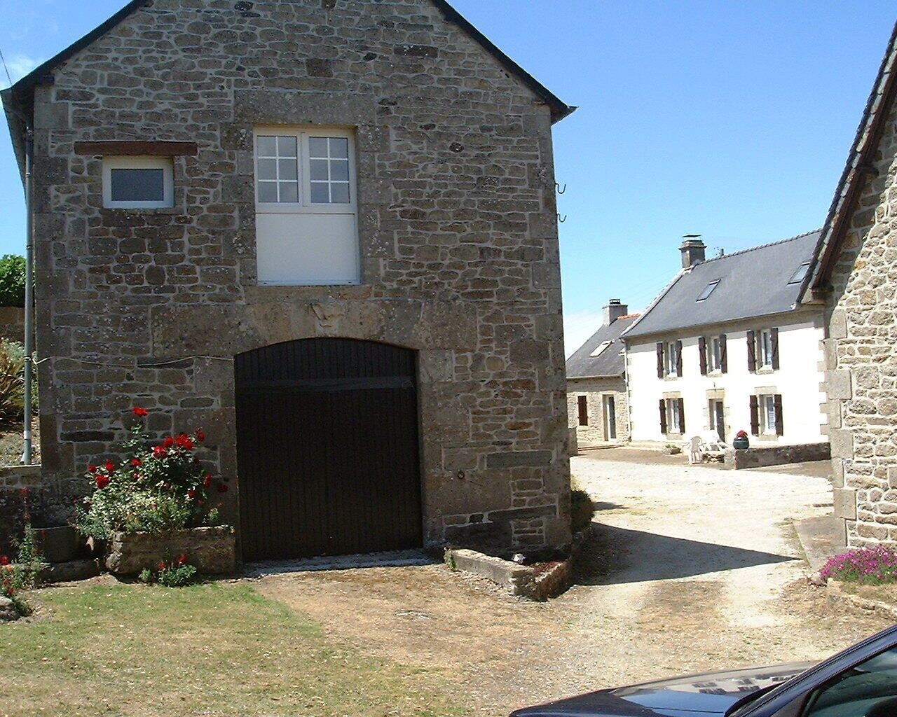 A stone building with a large wooden door and a small window.
