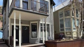 A two-story house with a front porch, a garage, and a fenced yard. - Pac. Street Studio: Style & space in heart of town (Telluride)