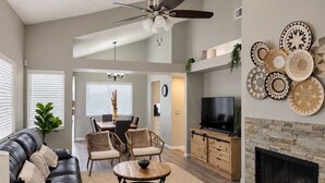 A spacious living room with a leather sofa, a coffee table, and a fireplace.