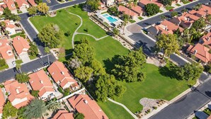 A residential area with houses, a swimming pool, and a well-maintained lawn.