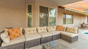 A covered outdoor seating area with a sectional sofa, two windows with blinds, and string lights. - Experience Deer Valley charm, just 14 mins from Grand Canyon University (Phoenix)