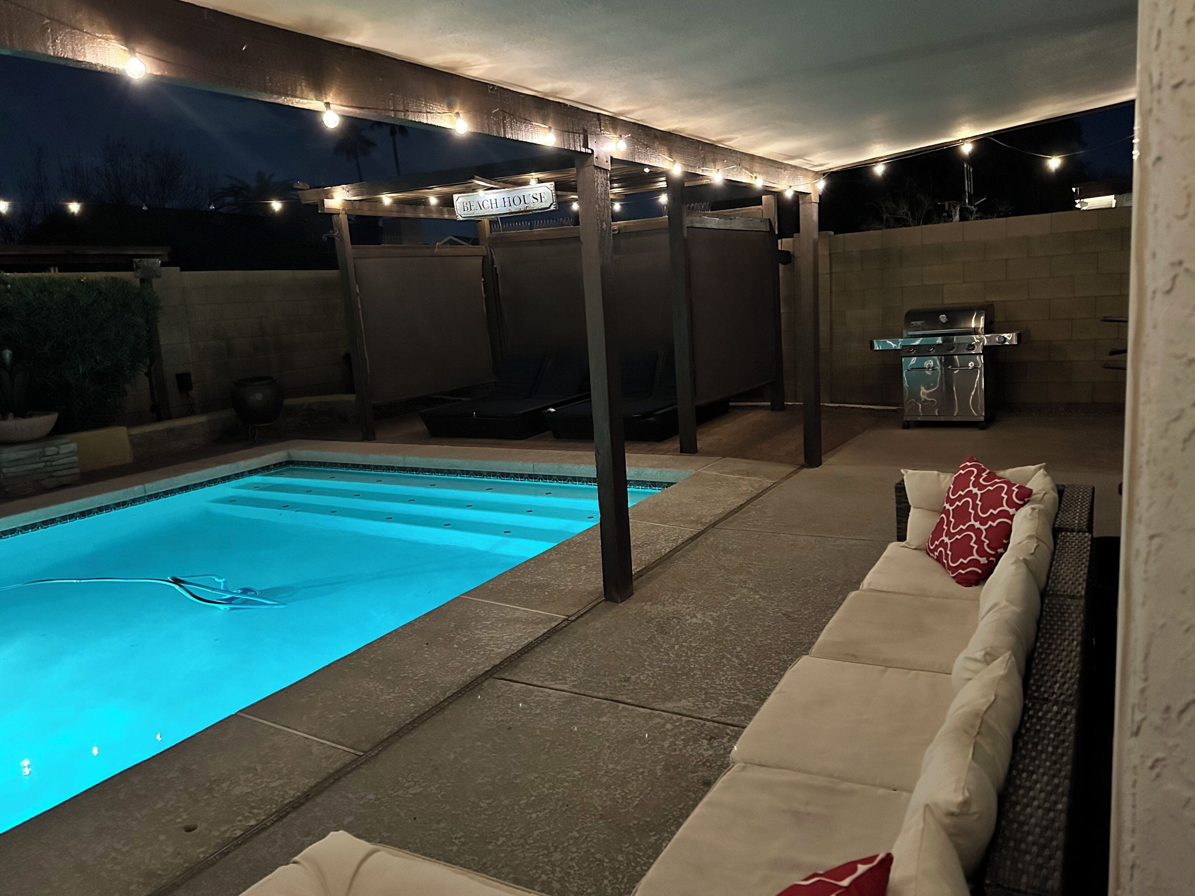 Ein Poolbereich im Freien mit überdachter Sitzgelegenheit und Grill.