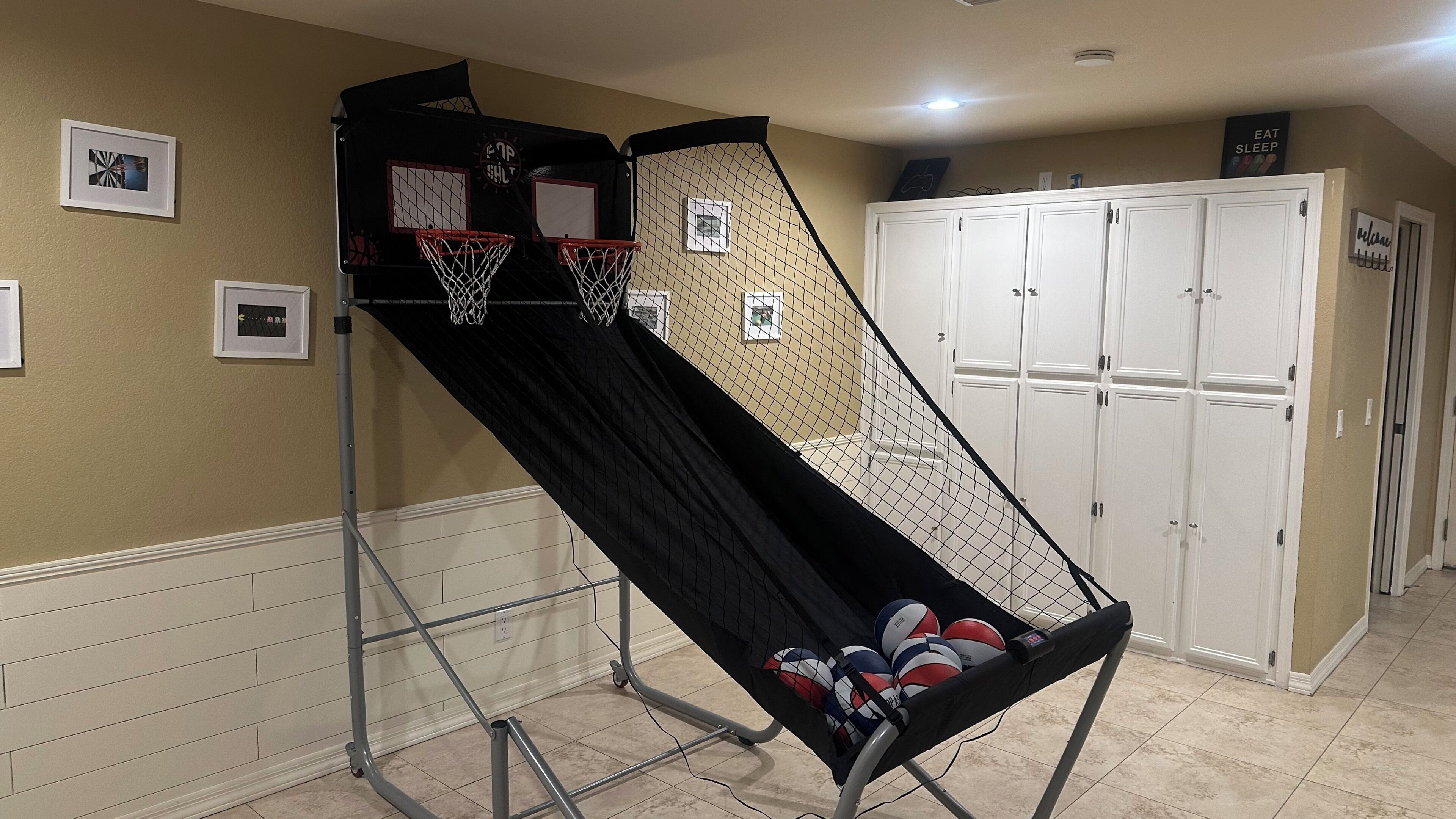 A home gym with a pull-up bar, a basketball hoop, and a storage cabinet.