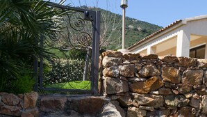 A stone staircase leading up to a house with a metal gate and a street lamp.
