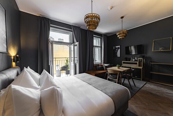 Una habitación de hotel moderna con una cama grande, un escritorio, un televisor y un balcón.