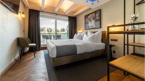 A modern hotel room with a large bed, a desk, and a view of the outdoors. - The Viaduct Suites & More (Prague)