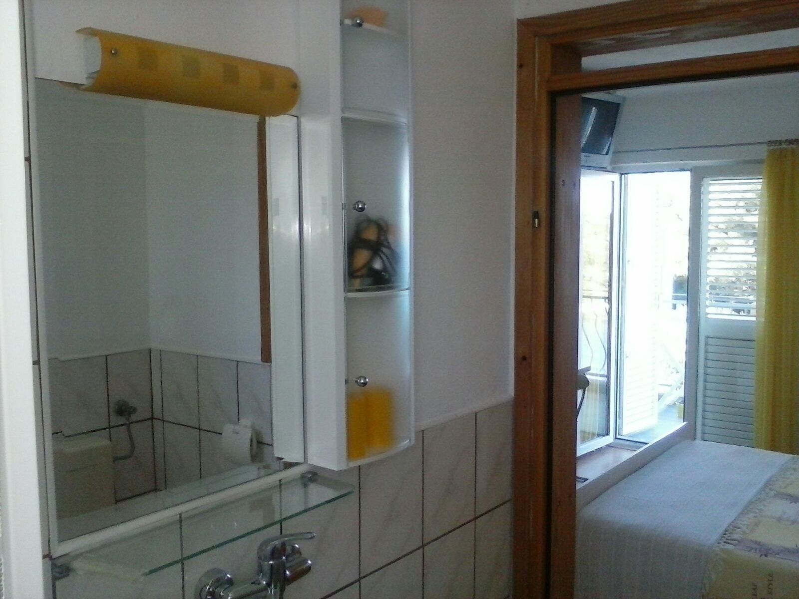 A bathroom with a glass shower enclosure, a mirror, and a toilet.