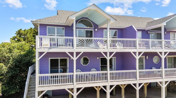 A two-story house with a balcony, a covered porch, and a garage. - 3BR Oceanview Duplex, beach and community pool access, in Spinnaker's Reach (Emerald Isle)