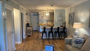 A modern living room with a sofa, a coffee table, and a kitchen in the background. - Peaceful 2BR Beach Condo with Pools, Tennis, Pickleball, Sauna, Gym & More! (Hilton Head Island)