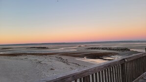 A wooden boardwalk leading to a beach with a sunset in the background. - Peaceful 2BR Beach Condo with Pools, Tennis, Pickleball, Sauna, Gym & More! (Hilton Head Island)