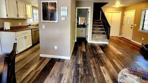A spacious kitchen with white cabinets, a wooden countertop, and a large painting on the wall. - Lovely Downtown Condo, Walk to Historic Downtown! (Flagstaff)
