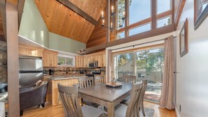 Une cuisine moderne avec des meubles en bois, un îlot central et un coin repas avec des chaises.