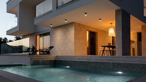 Un bâtiment moderne doté d’une piscine, d’un espace extérieur aménagé et d’un coin repas.
