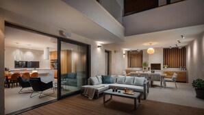 Uma sala de estar moderna com sofá, mesa de centro e área de jantar com cadeiras e mesa.