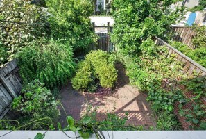 Stroll through the serene garden, surrounded by lush greenery and a brick pathway.