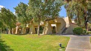 A building with a beige facade, multiple windows, and a staircase leading to an upper level. - Intimate Winter Oasis (Palm Springs)