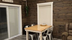 A dining area with a wooden table and chairs, a bench, and a sign that reads "Be our Guest".