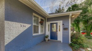 Una casa con fachada azul, una puerta principal y un buzón.