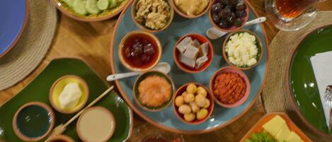 A table with various dishes and condiments, including bowls of nuts, olives, and cheese.