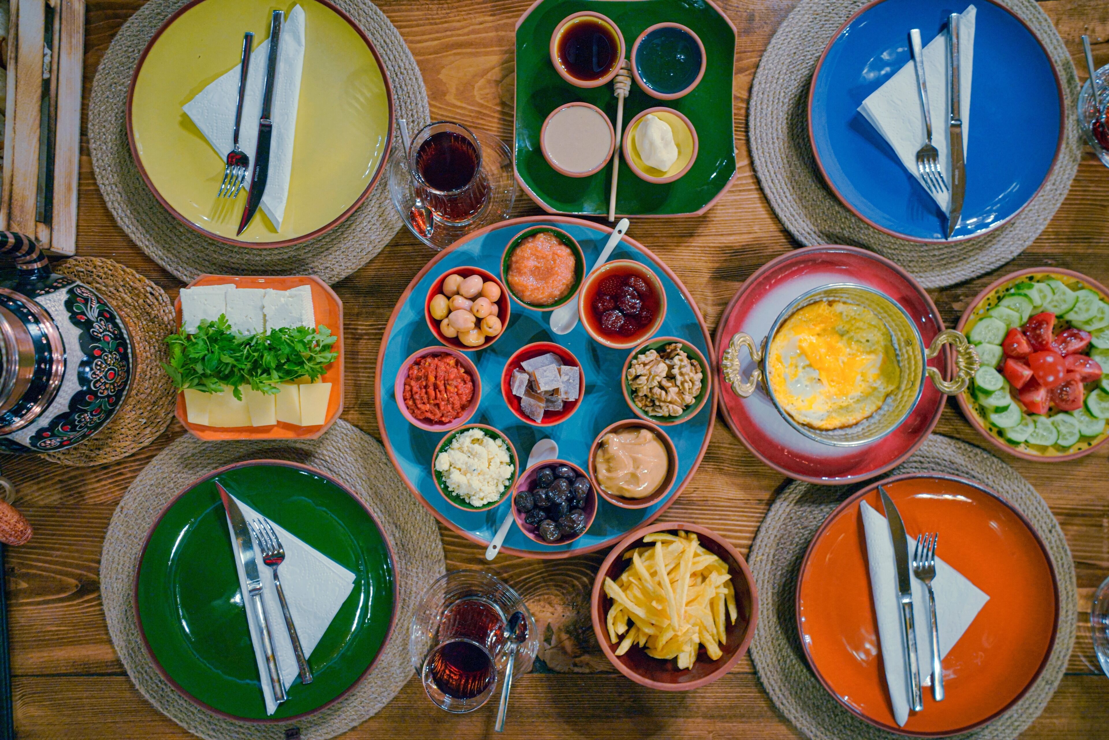 Una mesa servida con diferentes platos y cubiertos, indicando una preparación para comer.