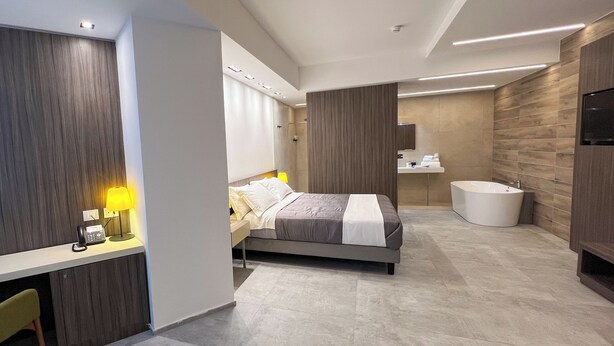 Una habitación de hotel moderna con cama, escritorio y una bañera grande.