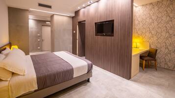 Un dormitorio moderno con una cama grande, un escritorio y un televisor.