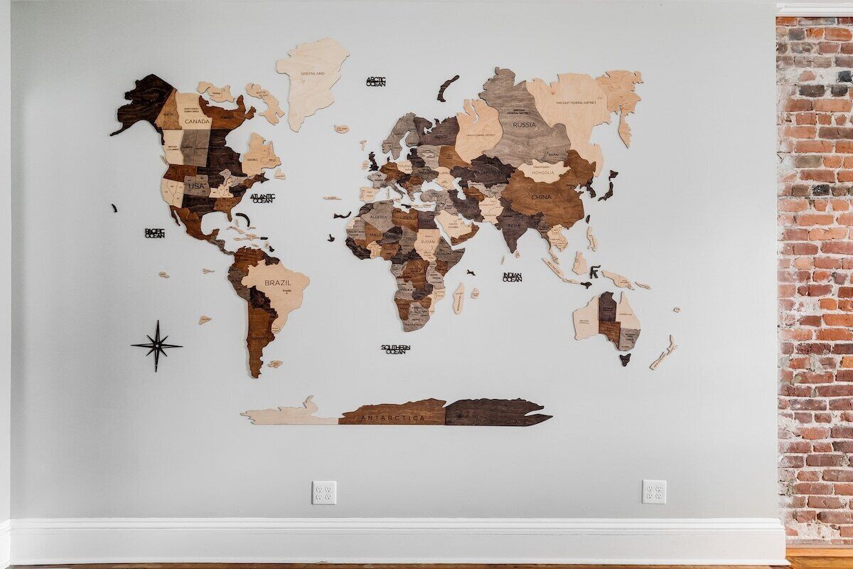Uma obra de arte de mapa-múndi na parede, com uma bússola.