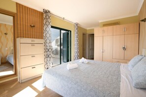 A bedroom with a bed, wardrobe, and a sliding glass door leading to a balcony. - #039 Family w/Private Pool and AC (Albufeira)