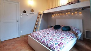 A bedroom with a bunk bed, a ladder, a bed with floral bedding, and wall-mounted lights. - Ô charme - 105m² apartment 15 min from Orléans (Olivet)