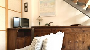 A living room with a TV, wooden cabinet, striped pillows, and a painting on the wall. - S256 - Sirolo, comfortable apartment in the center (Sirolo)