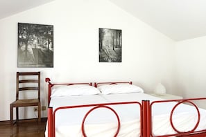 A bedroom with a bed, a chair, and two posters on the wall.