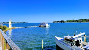 Un lac paisible, avec un quai, un petit bateau et un phare.