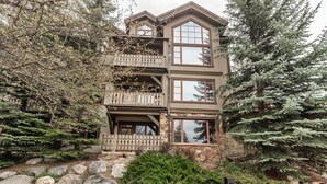 A multi-story building with a stone facade, balconies, and a stone retaining wall. - Luxurious Condo Gated Community Pool Hot Tubs (Edwards)