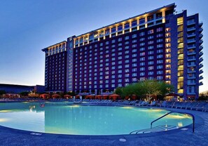 A high-rise hotel with a swimming pool in front. - Pool, Hot Tub,Pet-Friendly | Near NFL | Pink Skies (Scottsdale)