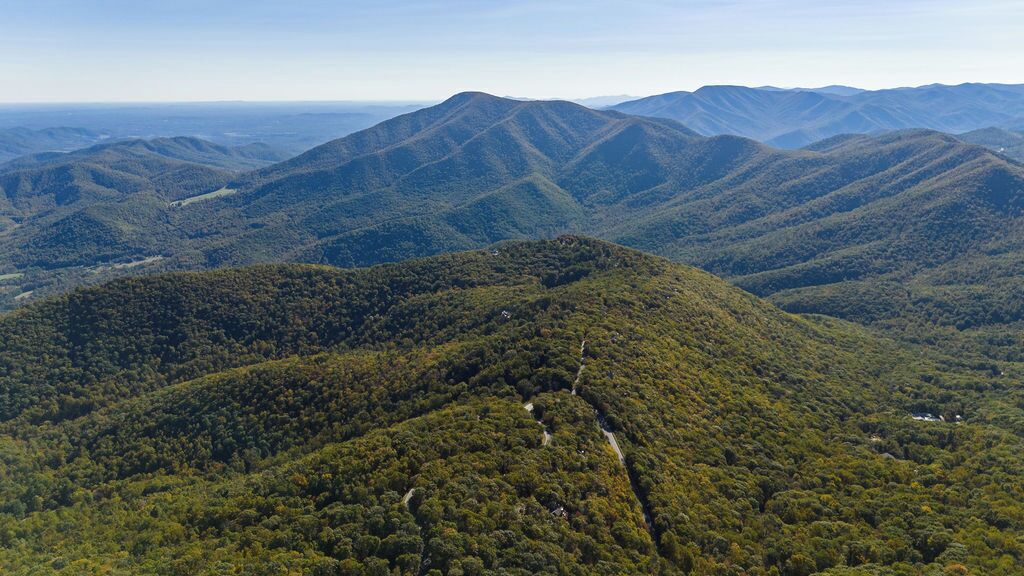 Un paysage montagneux, avec de vastes forêts et une route sinueuse.