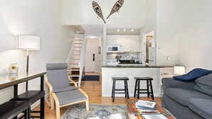 Eine moderne Wohnung mit Wohnzimmer, Küche und Essbereich.