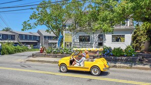 A yellow vintage car parked on a street with a building in the background. - Close to Bike Path 1 Mile to Beaches! (South Chatham)