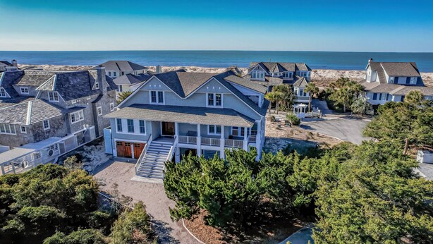 A coastal residential area with multiple houses, a beach, and a clear view of the ocean. - Reverse floor plan home with ocean views, updated kitchen and bathrooms! (Bald Head Island)