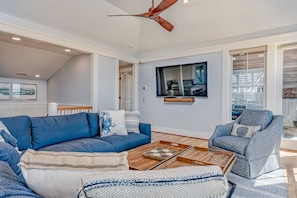 A modern living room with a blue sofa, a patterned armchair, and a wooden coffee table.
